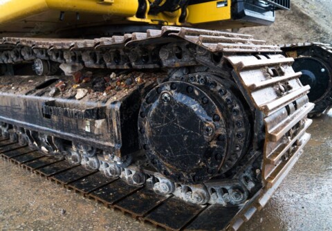 Zbliżenie na gąsienice koparki.