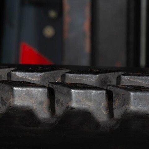 Zbliżenie na gumową gąsienicę maszyny budowlanej, pokazującą szczegóły bieżnika.