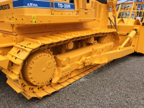 Żółte podwozie gąsienicowe z maszyny budowlanej typu dozer.