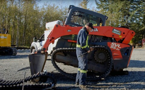 Technik naprawiający podwozie gąsienicowe maszyny Kubota SVL 95-2s.