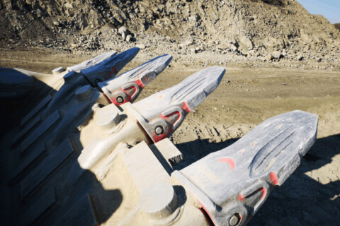 Zbliżenie na adaptery do zębów łyżki koparki.