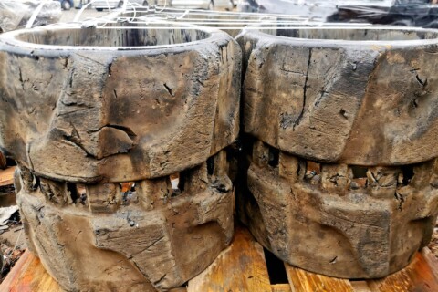 Zbliżenie na mocno zużyte gumowe gąsienice, na których widoczne są głębokie pęknięcia i ubytki.