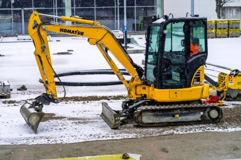 Minikoparka Komatsu wykonująca prace ziemne zimą na placu budowy