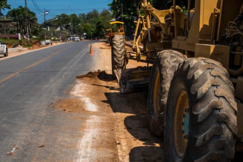 równiarka drogowa wyrównująca pobocze przy budowie drogi