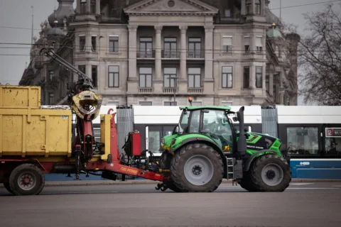 Ciągnik rolniczy z przyczepą poruszający się po drodze